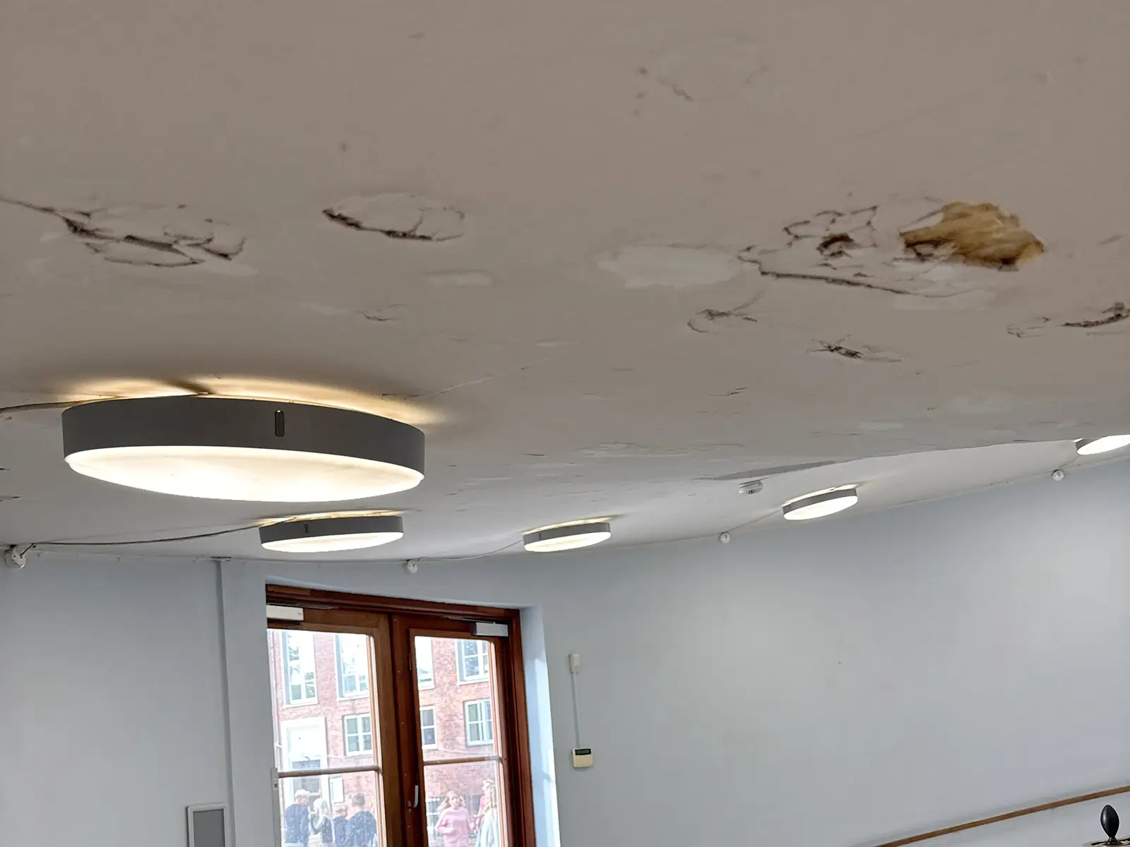 Akustikpudsloft fra anden producent med skader og uensartet overflade før renovering – Hz Renovare