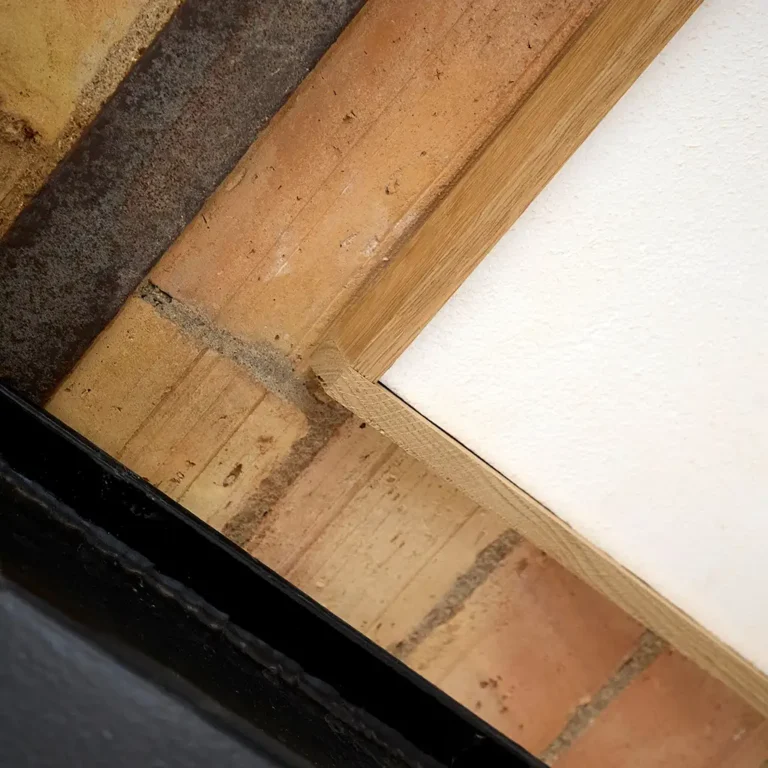 Detalje af egetræsramme, hvor Hz Flex 019 med akustikpuds møder de gamle mursten